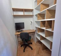 A workspace with a wooden decor floor and shelves in a 2-room apartment.