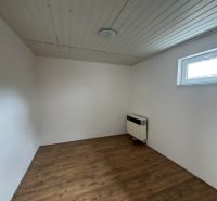 A room with a wooden decor floor and white walls in a 2-room apartment.