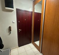 Entrance hall in a 3-room apartment with a mirrored wardrobe and light tiles.