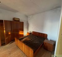 A bedroom with retro furniture and a wooden decor floor in a family house.