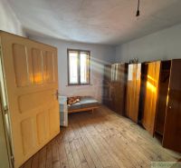 A room in a family house with a floor featuring a wooden decor and simple furnishings.