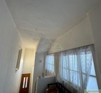 The interior of a family house with a narrow hallway and curtain windows.