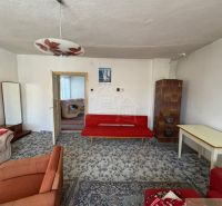Living room in a family house with a sofa set and a tiled stove.