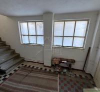 Interior of a family house with a staircase, carpet, and large windows.