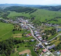 An aerial view of the village of Karná surrounded by hills and residential land.