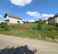 A house surrounded by greenery in Karna, bordered by a fence, ideal for residential land.