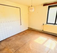 Unfurnished room with a window, radiator, and wooden decor flooring in a family house.