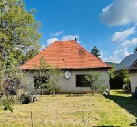 A family house in Pažiť with a red roof in a landscaped garden.