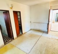 Interior with old flooring, wooden doors, and a radiator in a family house.