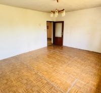 A room in a family house with a wooden decor floor and a chandelier.