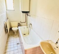 A bathroom in a family house with a bathtub, sink, and toilet.