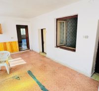 Interior of a family house with a plastic chair, doors, and an electrical box on the wall.