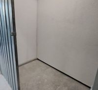 Small storage spaces with metal doors and concrete flooring in a two-room apartment.