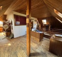 Attic room in a family house with wooden decor, antique furniture, and accessories.