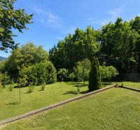 A garden with a lawn and trees in Považská Bystrica on Klučina Street near the Cottage.