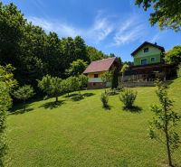 A cottage on Klučina in Považská Bystrica with a well-maintained garden, trees, and green grass.