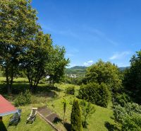 The garden of the cottage at Klučina in Považská Bystrica with lush greenery and chairs.