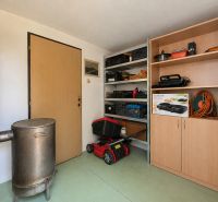 Storage space in the cottage with a stove, shelves, and tools.