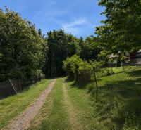 A cottage on Klučina Street in Považská Bystrica surrounded by greenery and a blue sky.