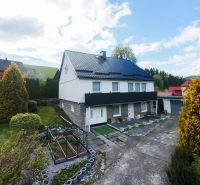 A family house in Makov surrounded by a well-maintained garden with a greenhouse and paved paths.