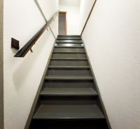 A staircase with a black railing in a family house.