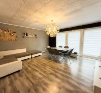 Living room in a family house with a wooden decor floor and large sofa seating.