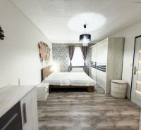 A bedroom in a family house with a wooden decor floor and tasteful furnishings.