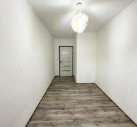 A narrow hallway in a family house with a wooden decor floor and a white ceiling.