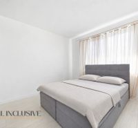 Bright bedroom with a bed, wardrobe, and curtains in a family house.