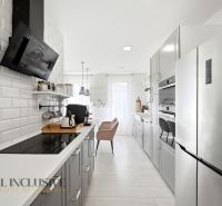 A stylish kitchen in a family house with modern appliances and white paneling.
