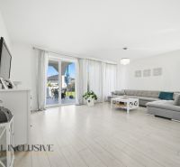 Living room in a family house with a wooden decor floor and a large sofa set.