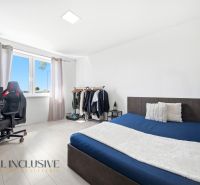 A room in a family house with a bed, a desk, and a wardrobe stand, flooring with a wooden decor.