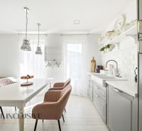 A bright kitchen in a family house with an elegant interior and a wooden decor floor.