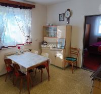 Dining room in a family house with vintage furniture, floral decorations, and a passage to the bedroom.