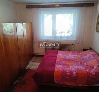 Bedroom in a family house with a bed, wardrobe, and window. It has a floor with a wooden decor.