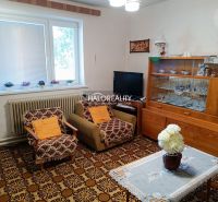 A living room in a family house with retro furniture and a patterned carpet.