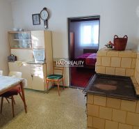 Kitchen in a family house with a stove, dining table, and display cabinet.