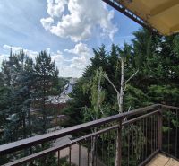 The view from the balcony of the 4-room apartment in Myjava includes trees and a panorama of the city.