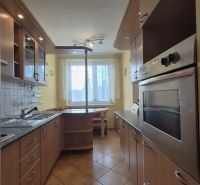 A kitchen with a kitchenette in a 4-room apartment, floor with wood decor.