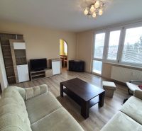 Living room in a 4-room apartment with a wooden decor floor, light furniture, and a seating set.