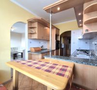 A kitchen in a 4-room apartment with a wooden floor decor and arched passages.
