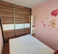 A bedroom in a 4-room apartment with a wooden decor floor and a bear wall sticker.