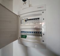An electrical distribution box in a 2-room apartment with open doors and a socket.