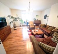 Living room in a two-room apartment with a wooden decor floor and a comfortable sofa.
