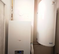 Heating appliances in the bathroom of a two-room apartment with a wooden decor floor.