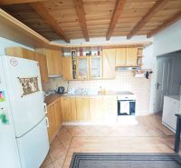 A kitchen with a wooden decor floor and ceiling beams in a 2-room apartment.