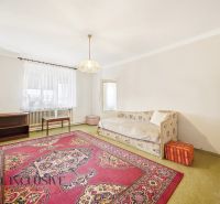 Living room in a family house with a carpet and a sofa, simple interior.
