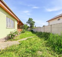 A garden at a family house in Hviezdoslavov with a lawn and flowers, bordered by a fence.