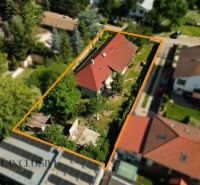 A family house in Hviezdoslavov with a red roof, surrounded by greenery and other buildings.