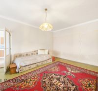 A room in a family house with a bed, light, and an oriental carpet.